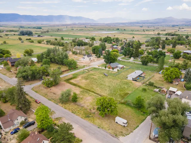 Expansive land parcels framed by mature trees, surrounded by distant mountains and open fields
