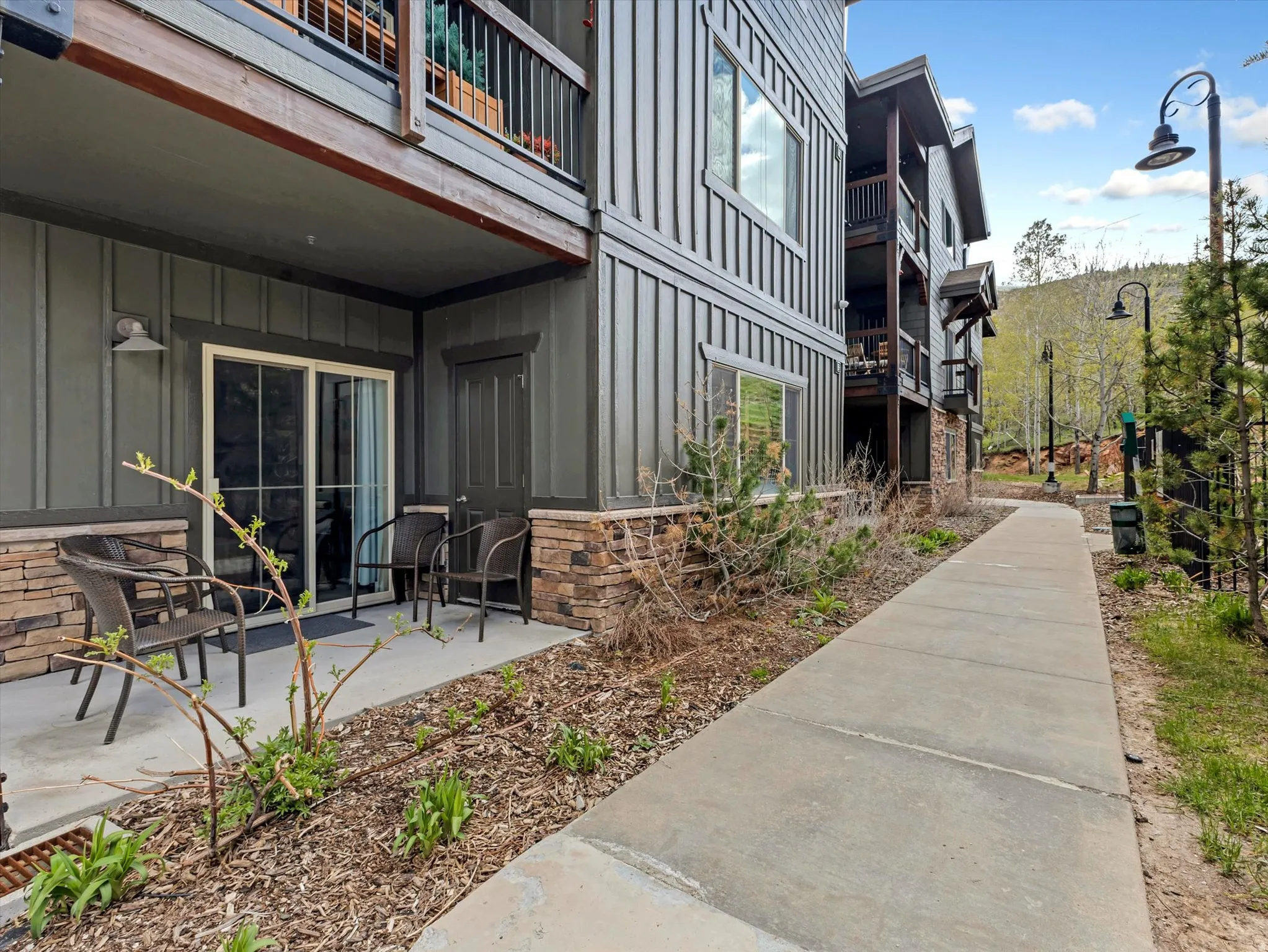 Ground-level patio entry featuring sliding glass doors and stone facade accents