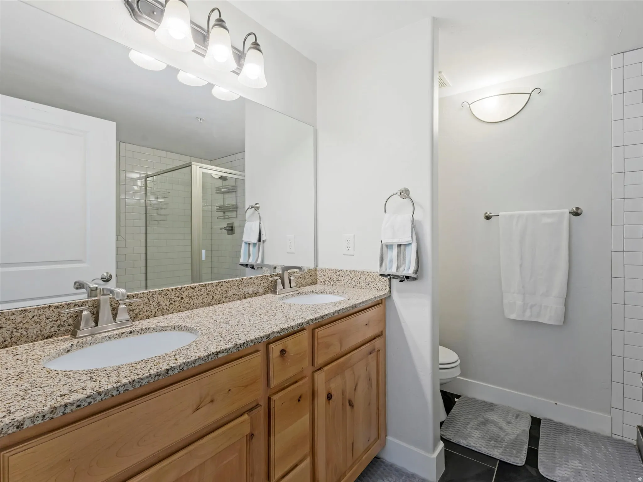 Double vanity with granite-style countertop and brushed nickel fixtures