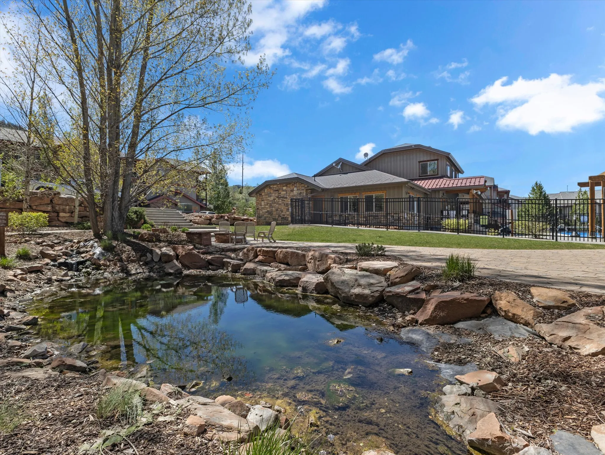 Natural water feature surrounded by rock landscaping and mature trees