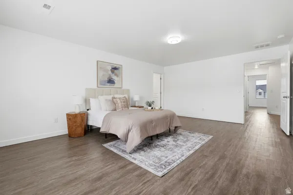 Spacious interior featuring wood-finish flooring, white walls, and an overhead flush-mount light fixture