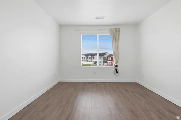 Bedroom 2 Bright interior featuring wood-finish flooring, white walls, and white trim