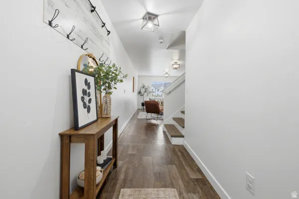 Entryway featuring wood-finish flooring, white walls, and a built-in coat rack