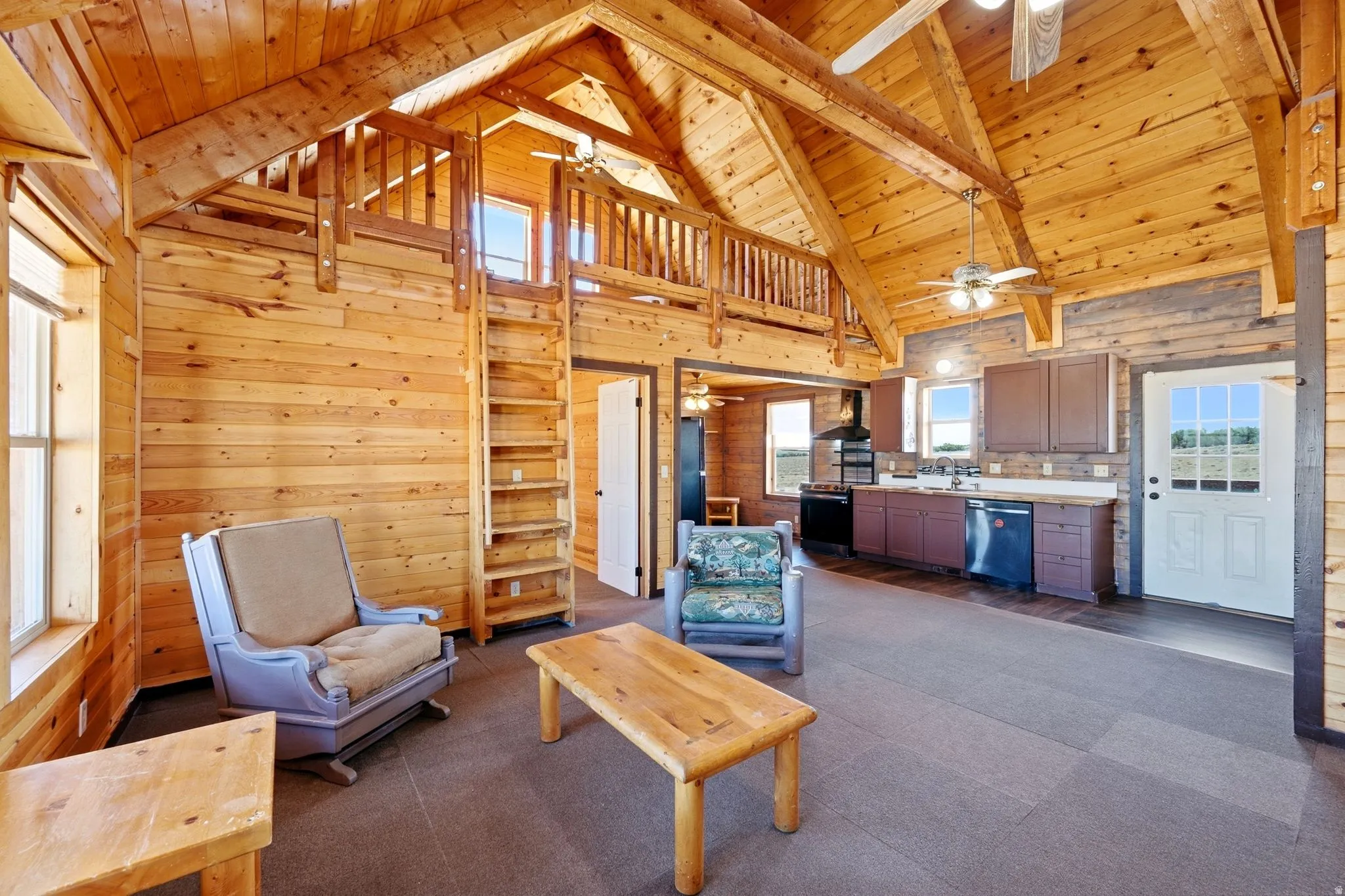 Vaulted wood-finish ceilings and exposed beams enhance the open-concept living space