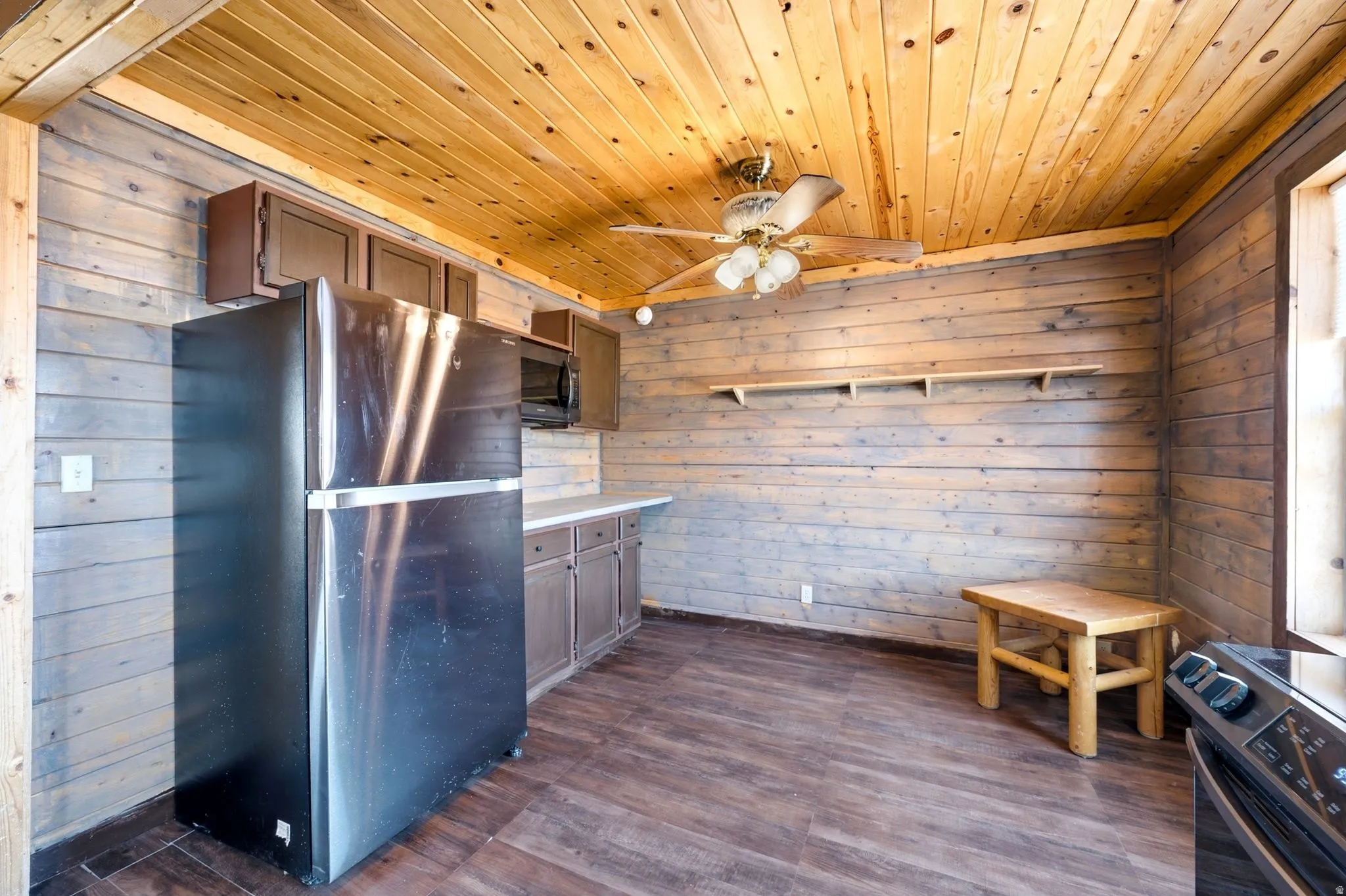 Kitchen area featuring a stainless steel refrigerator, built-in microwave, and wood-finish flooring