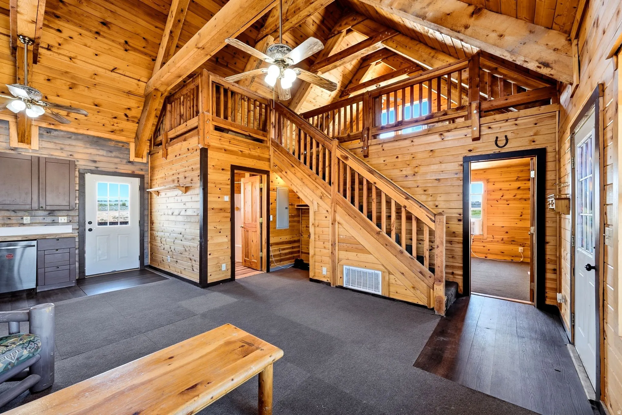 Vaulted wood-paneled ceilings with exposed beams, wood-finish flooring, and a second-story loft