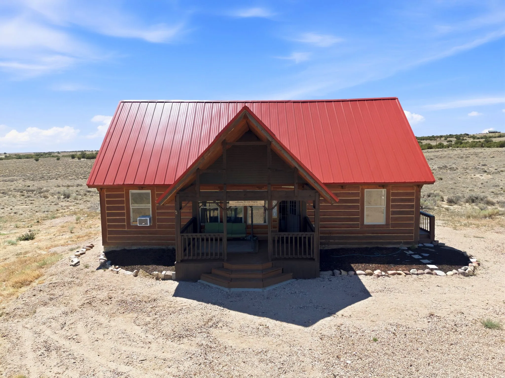 Cabin-style residence featuring a prominent red metal roof