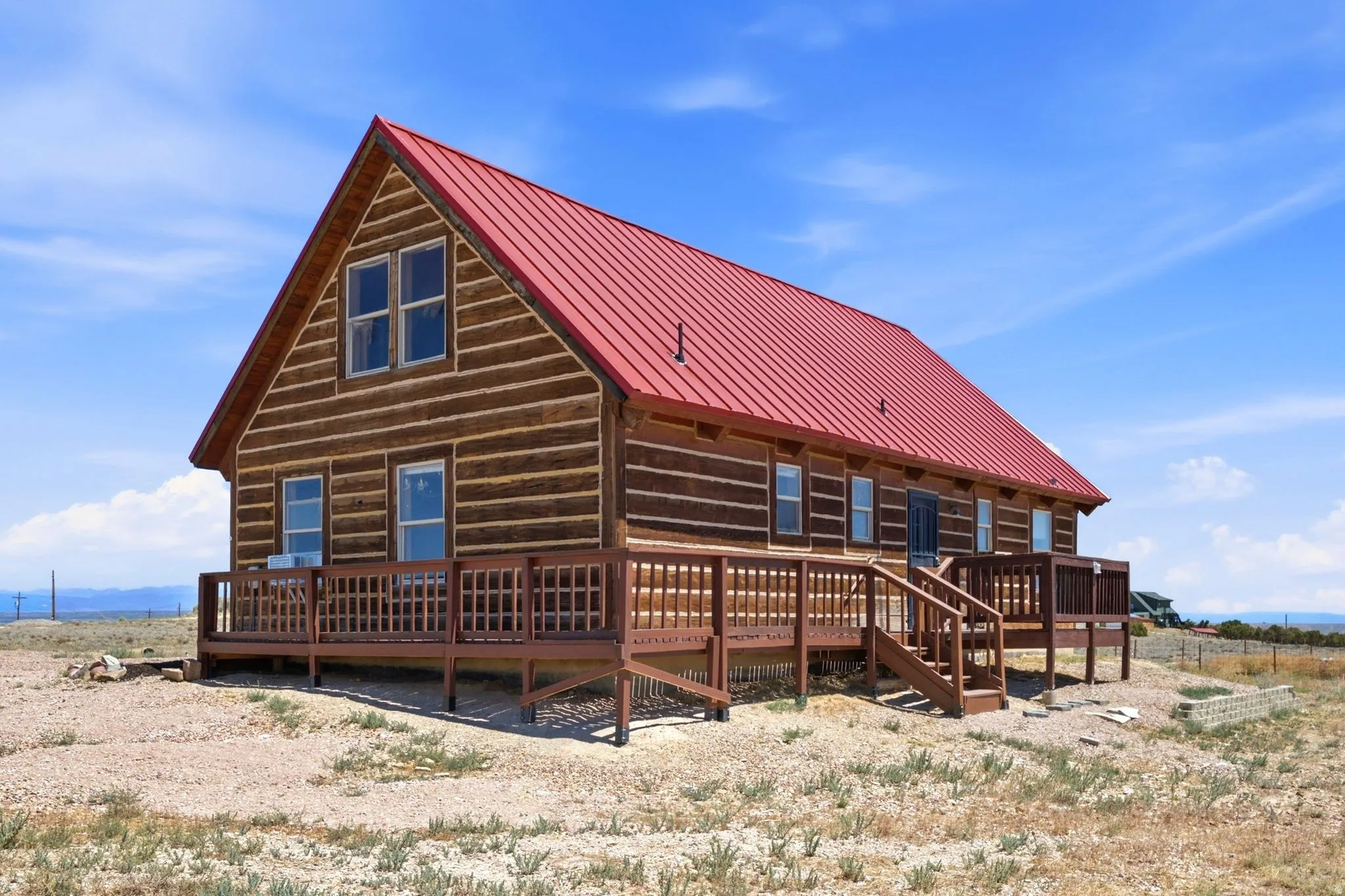 Log cabin exterior featuring a vibrant red metal roof