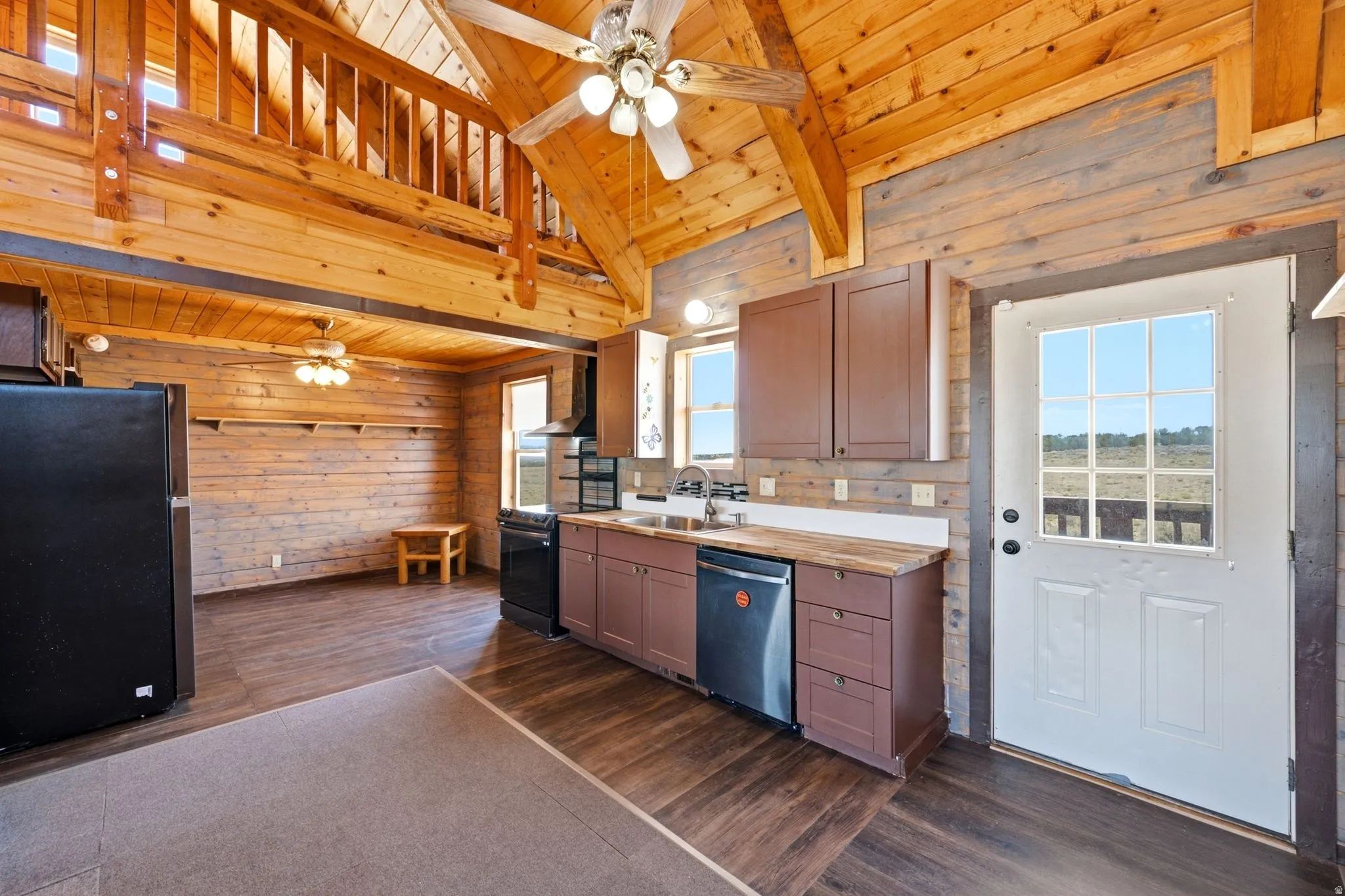 Open-concept living space with exposed wood beam ceilings and wood-finish flooring