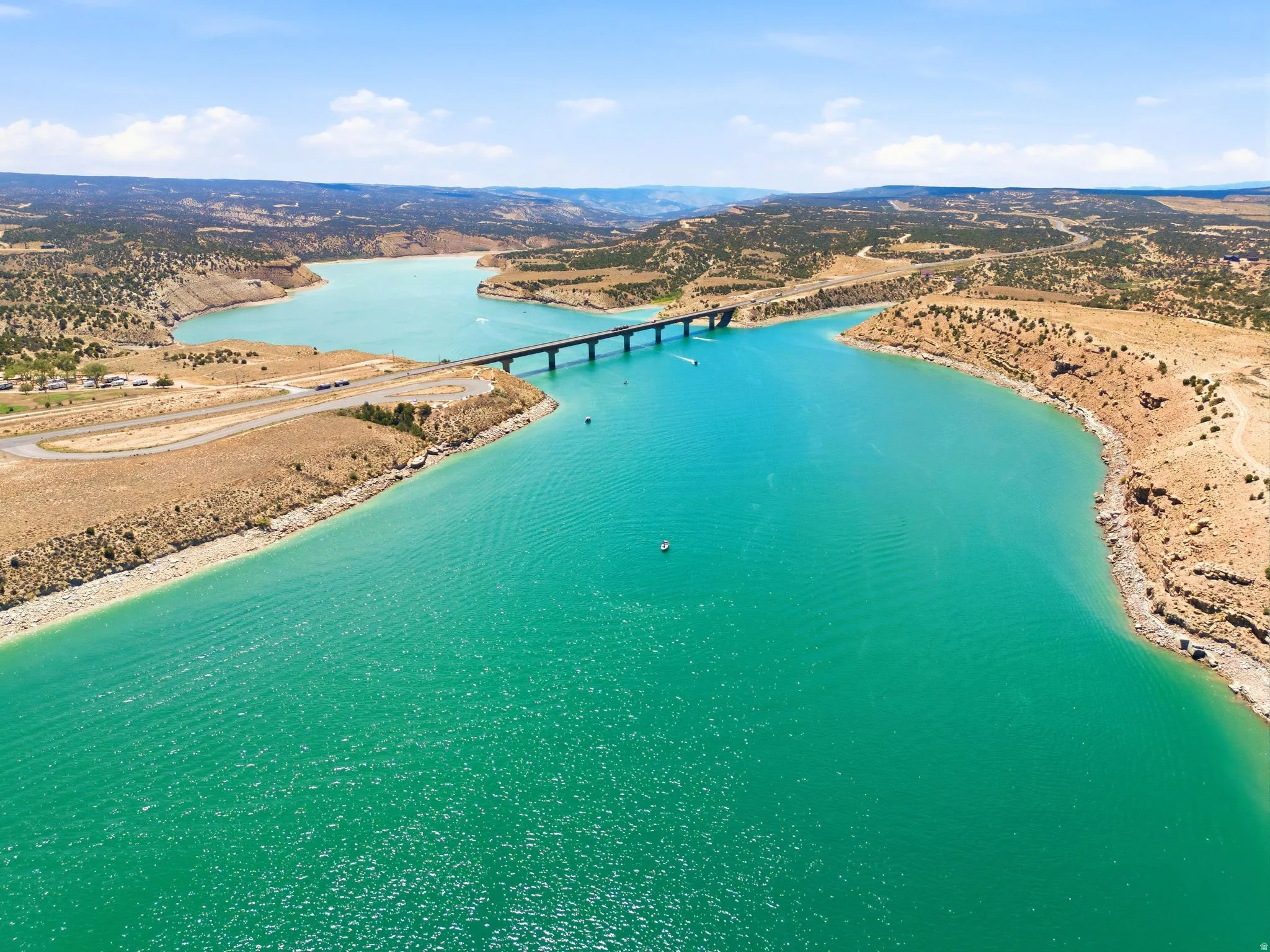 Starvation Reservoir with vibrant turquoise hues, bordered by arid land and distant hills