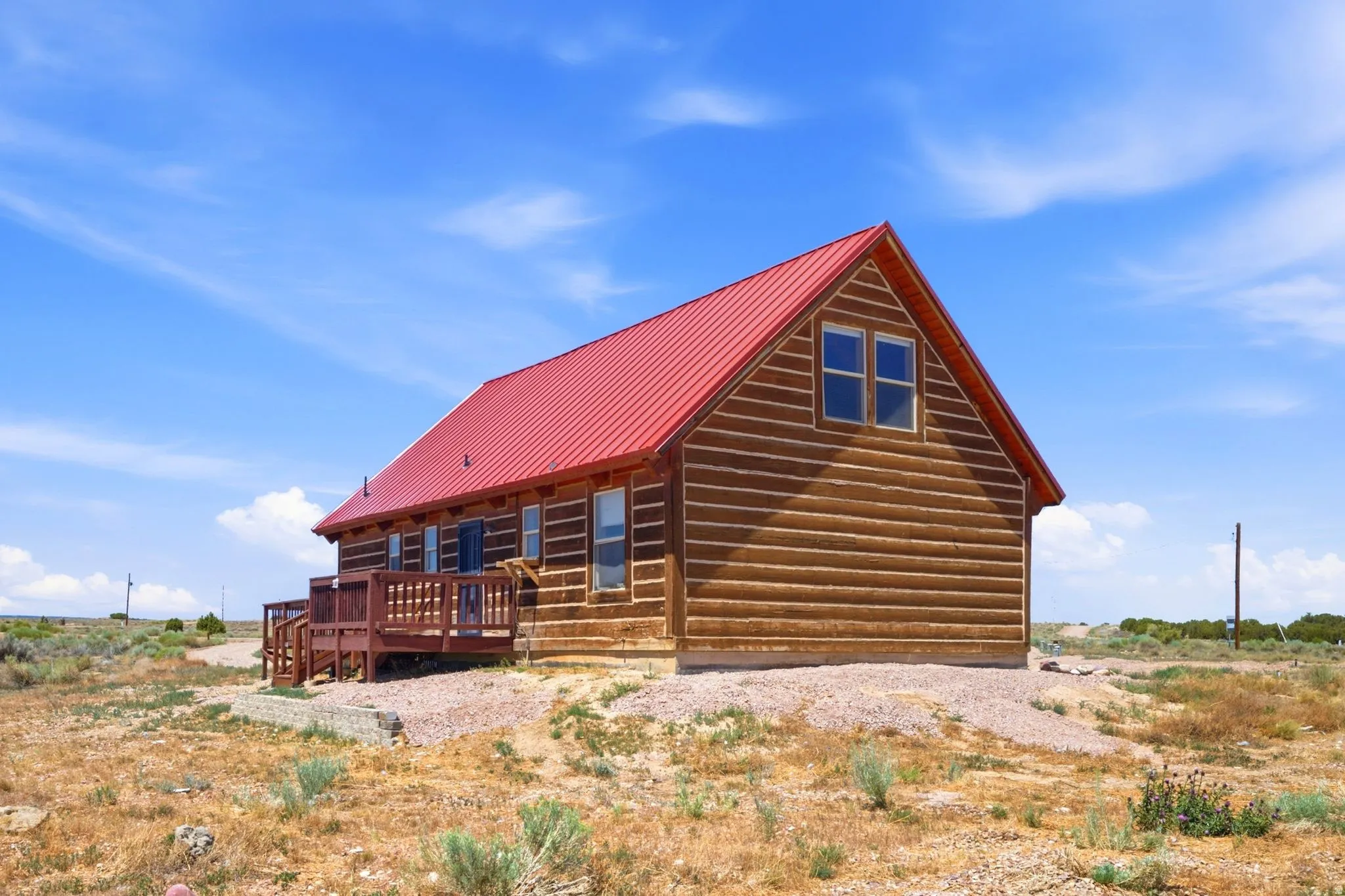 Log-style exterior featuring a vibrant red metal roof