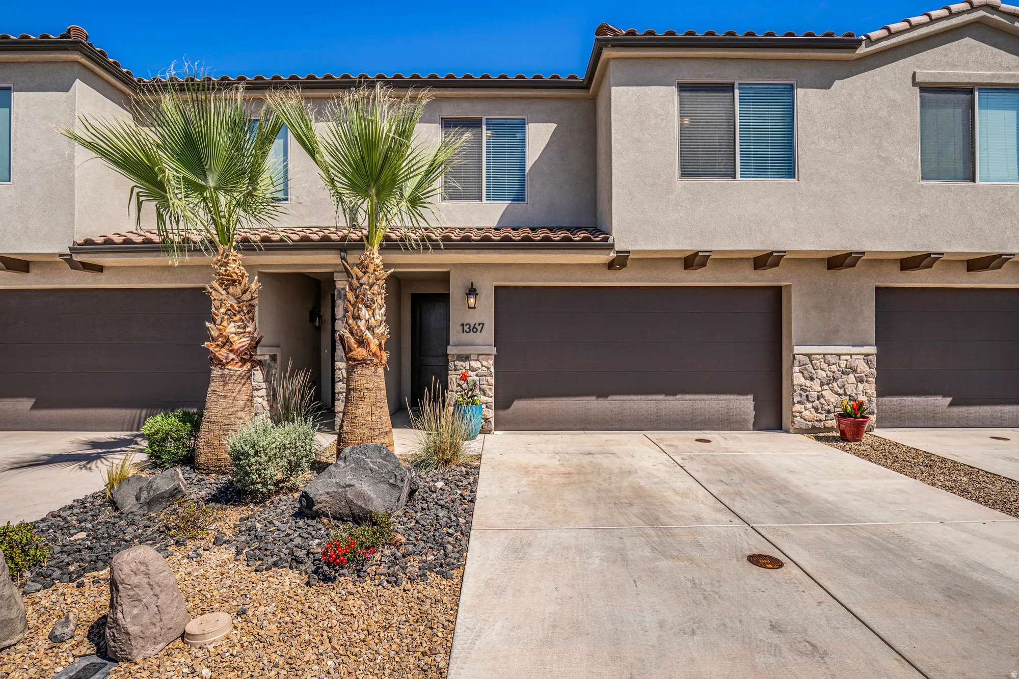 Stucco exterior with stone accents and a terracotta tile roof