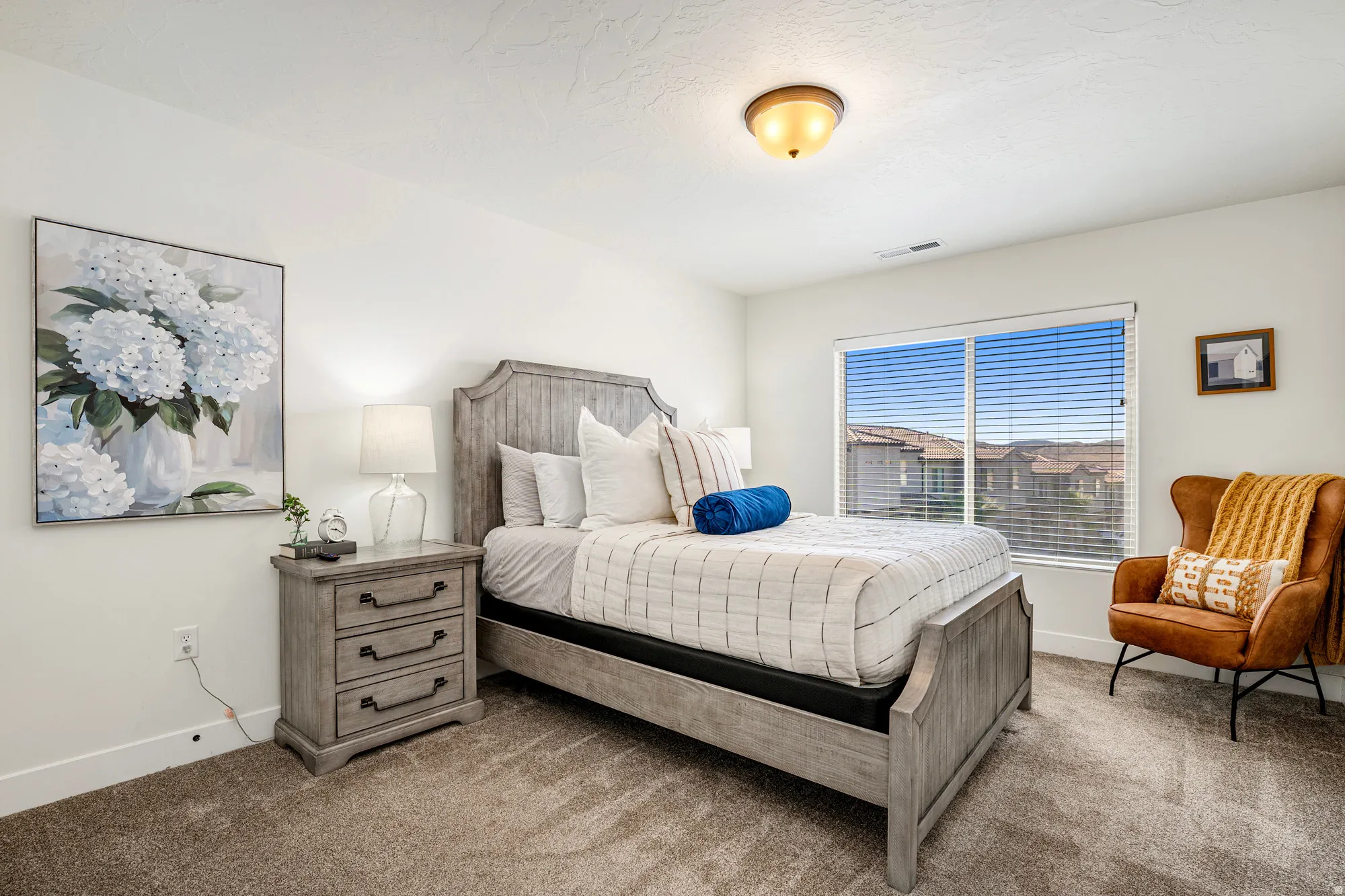 Spacious room featuring neutral paint, soft carpet flooring, and a large window with blinds
