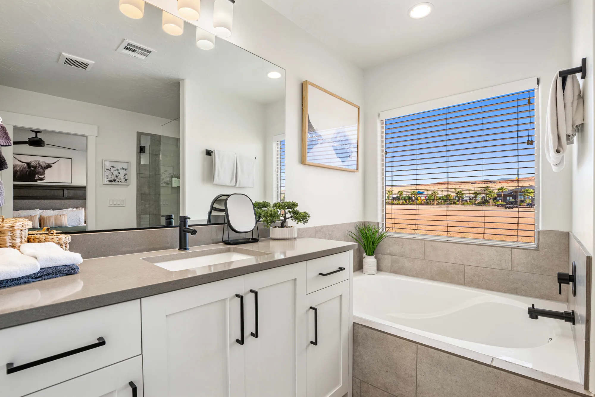 Modern bathroom featuring a built-in tub, a large window, and a vanity with a rectangular undermount sink