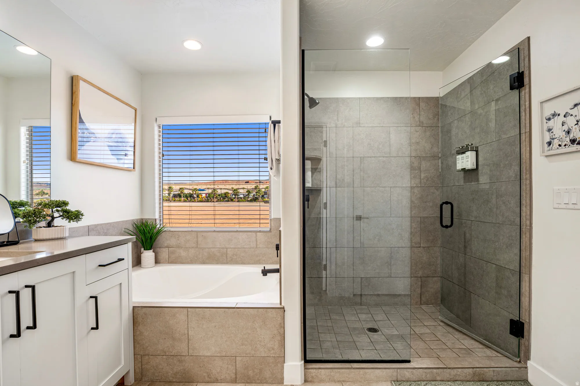 Modern bathroom featuring a glass-enclosed shower with tile surround, a built-in soaking tub with a tiled facade, and a white vanity with dark hardware and a light-toned countertop