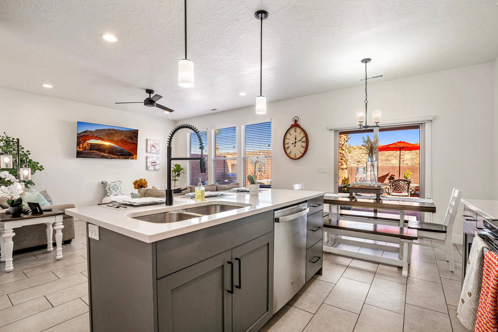 Open-concept living space featuring an island kitchen, stainless steel appliances, tile flooring, a sliding glass door to the patio, and recessed lighting