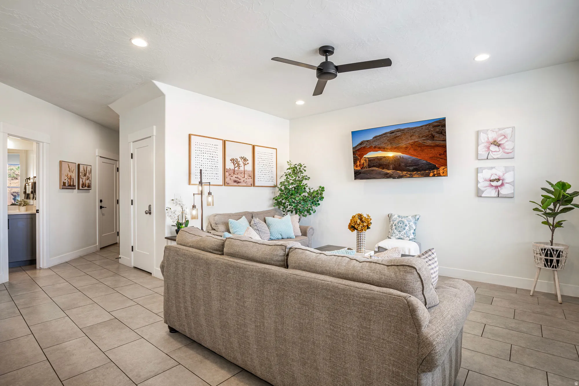 Spacious living area featuring neutral tile flooring, recessed lighting, and a contemporary ceiling fan