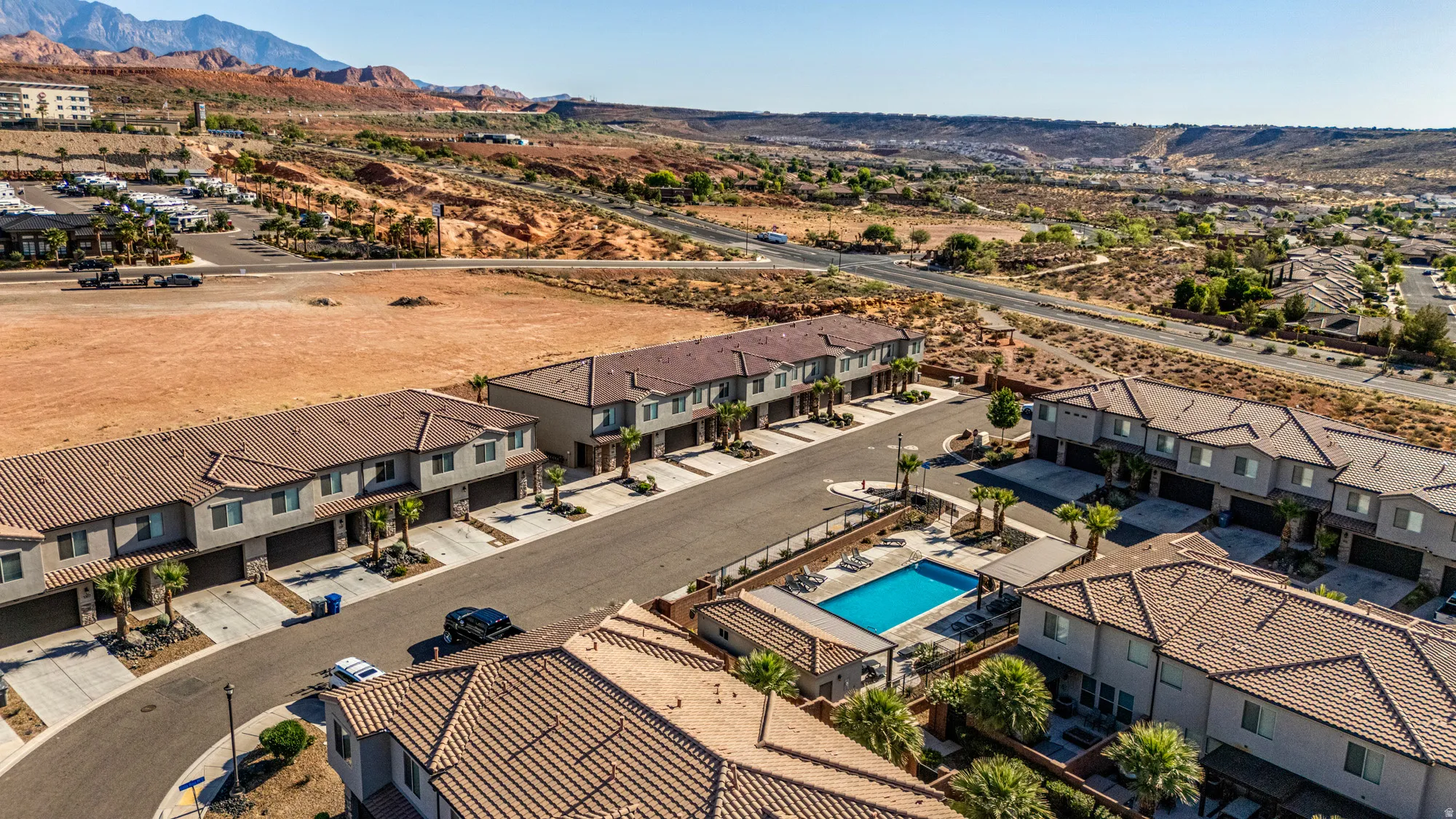 Community of multi-story townhomes featuring tile roofs and attached garages