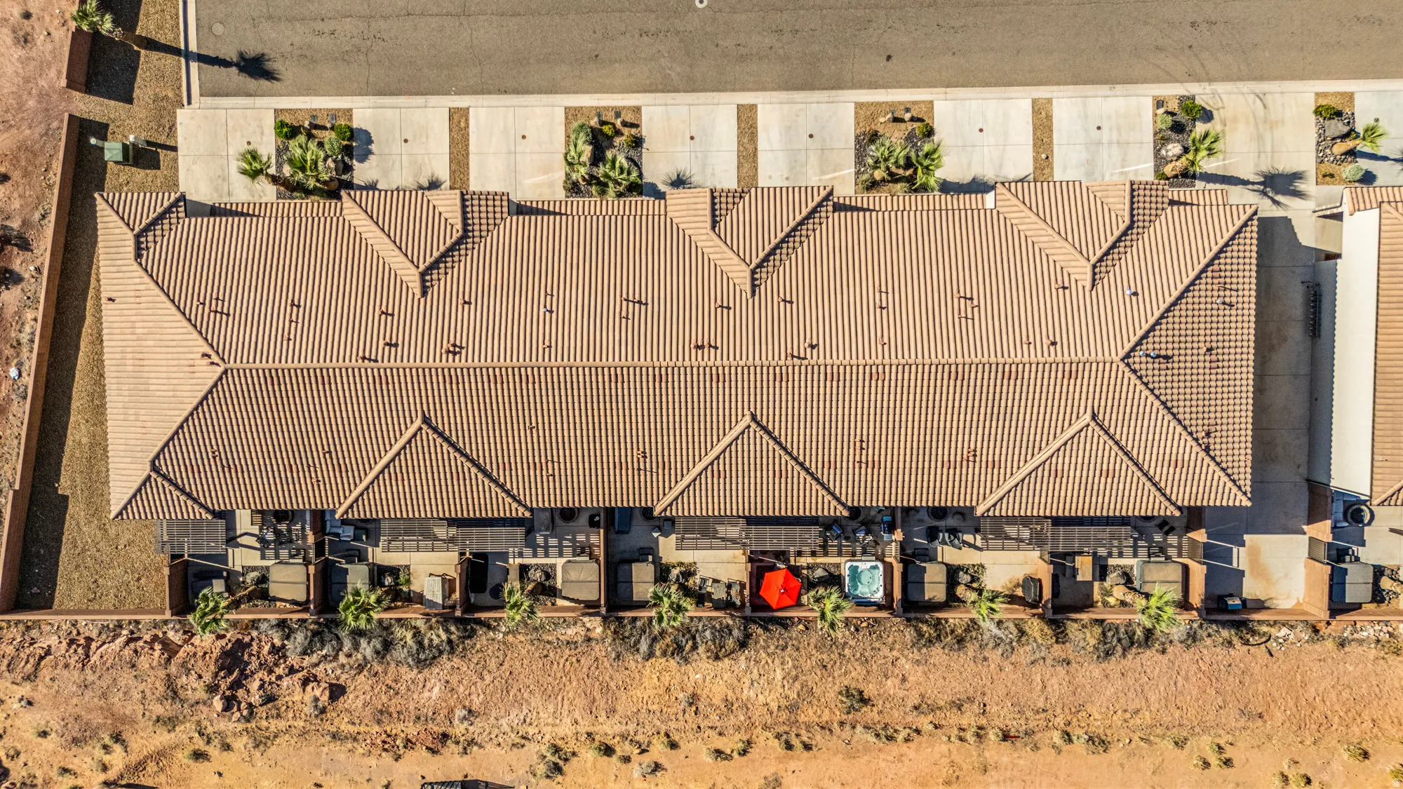 Aerial perspective showcasing a complex of attached residences featuring terracotta-style tile roofing