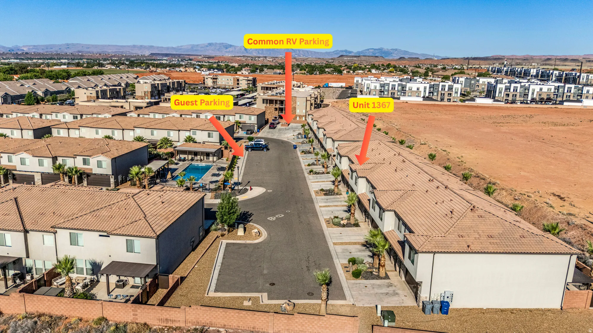 Aerial perspective of a multi-unit property featuring uniform stucco exteriors and terracotta-style roof tiles