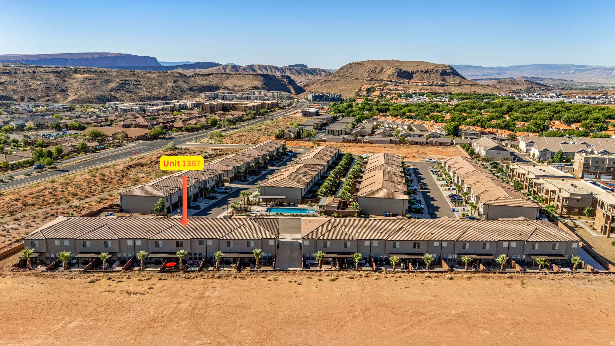 Aerial perspective of a multi-unit residential complex featuring uniform architecture and desert landscaping