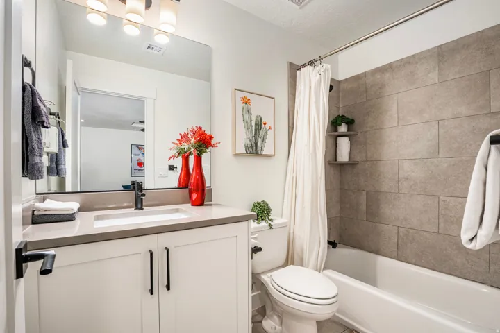 Bathroom featuring a white vanity with a light-toned countertop, an undermount sink with a matte black faucet, and a large mirror
