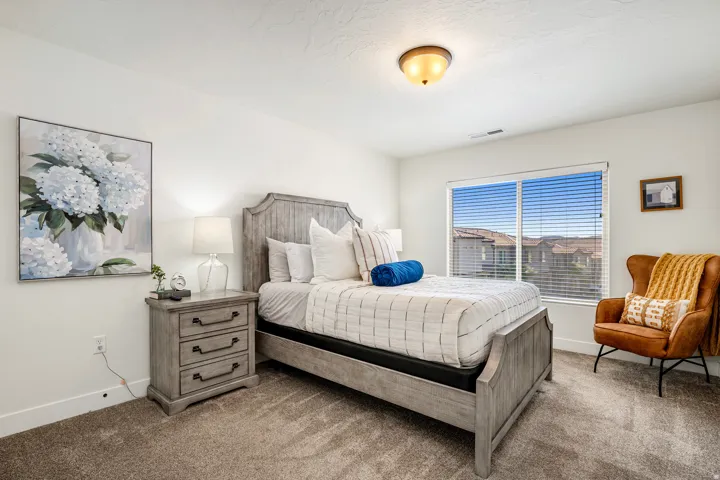 Spacious room featuring neutral paint, soft carpet flooring, and a large window with blinds