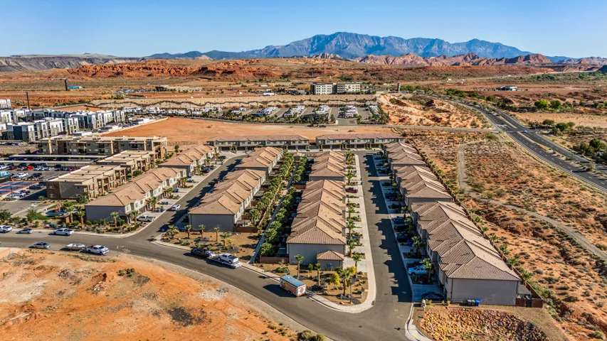 Townhome community featuring structured rows of residences, multi-story buildings, and a desert landscape