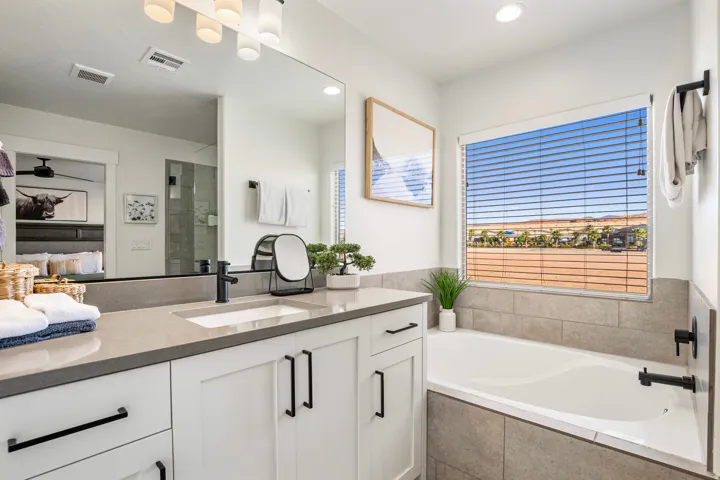 Modern bathroom featuring a built-in tub, a large window, and a vanity with a rectangular undermount sink