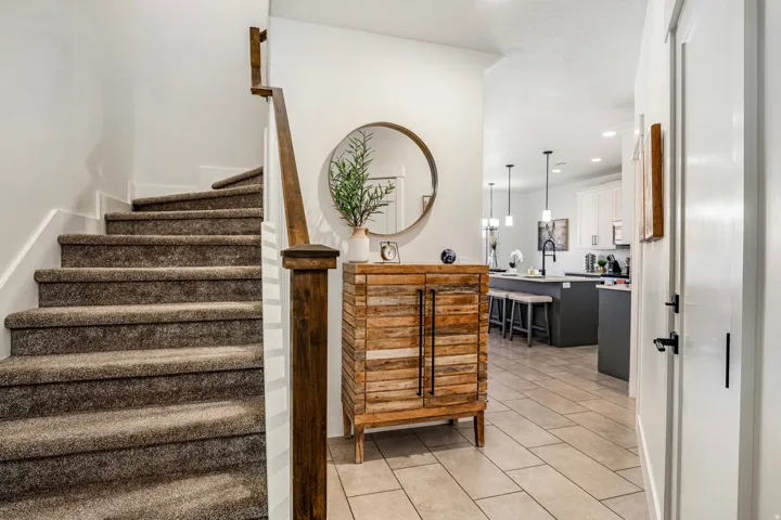 Staircase with carpeted treads and a dark wood newel post