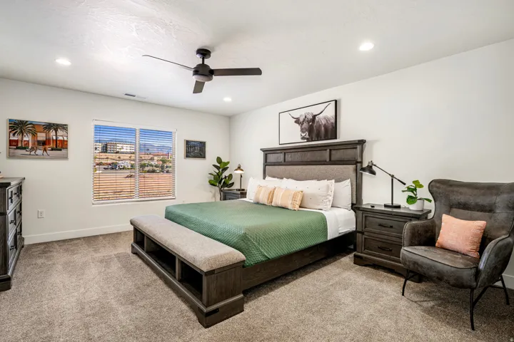 Spacious bedroom featuring neutral carpeting, recessed lighting, and a modern ceiling fan