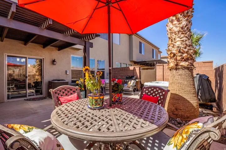 Paved patio featuring a pergola, sliding glass door entry, and an established palm tree
