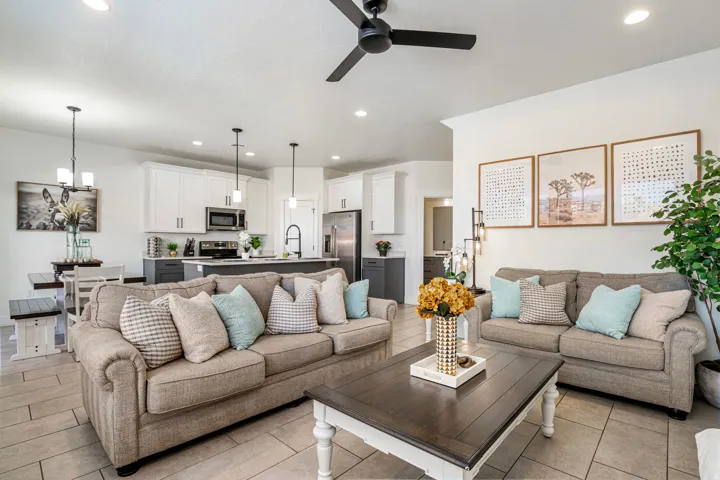 Open-concept living area featuring wood-finish tile flooring, a dark-toned ceiling fan with integrated lighting, and recessed ceiling lights