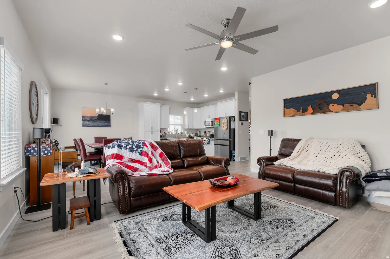 Open-concept living area featuring light wood-finish flooring, recessed lighting, and a modern ceiling fan