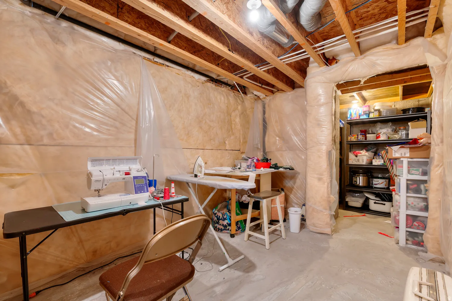 Unfinished basement space featuring exposed wood joists and concrete flooring