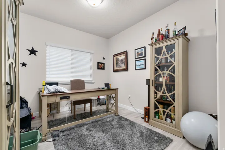 Light-filled room featuring wood-finish flooring, a contemporary ceiling light fixture, and a window with blinds