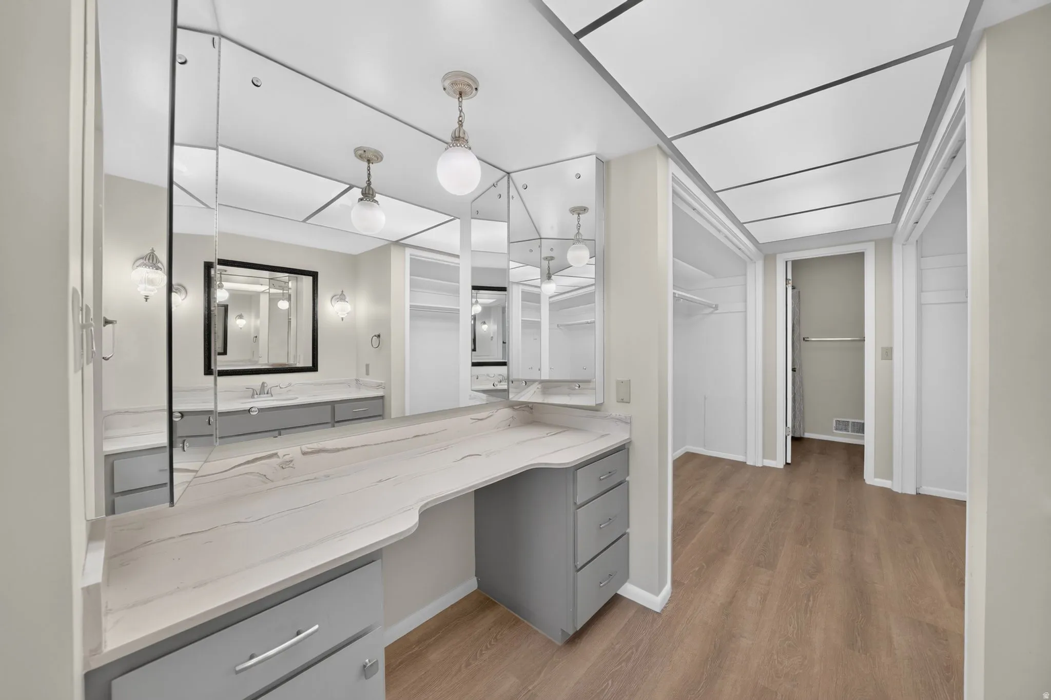 Vanity area featuring a built-in makeup desk with a light-colored countertop and grey cabinetry