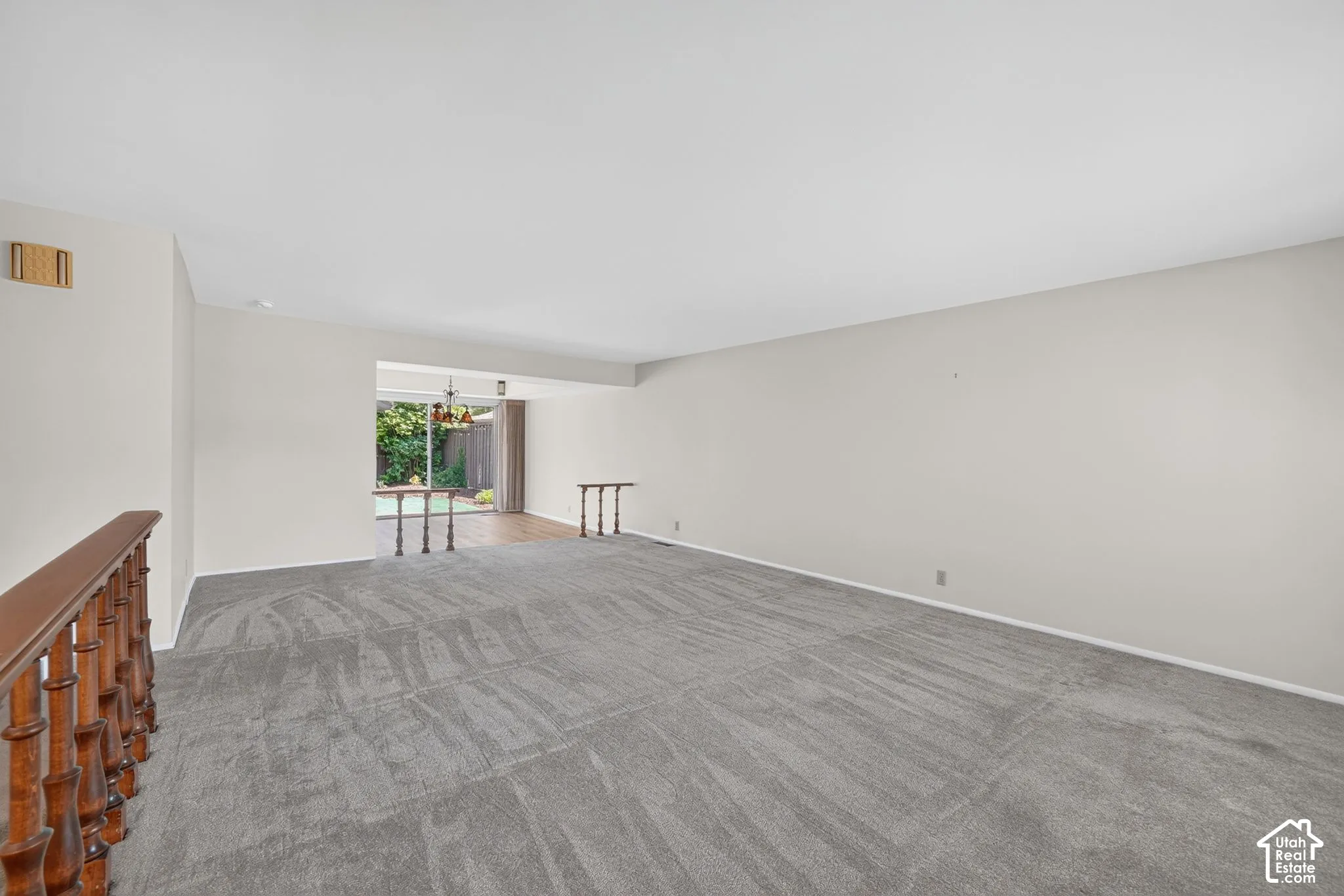 Spacious interior featuring neutral wall tones and updated gray carpet