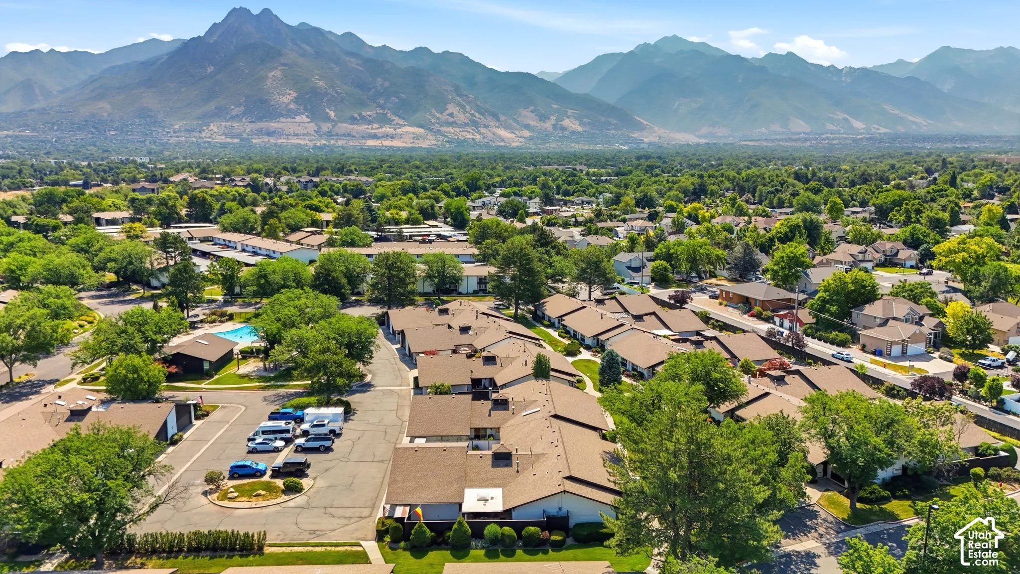Expansive community with varied architectural styles, mature trees, and mountain scenery