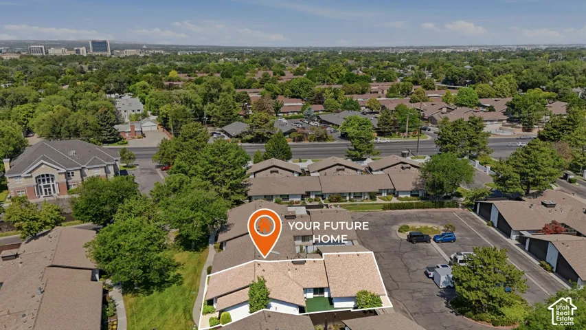 Aerial view showcasing a residential property within a green, tree-lined neighborhood