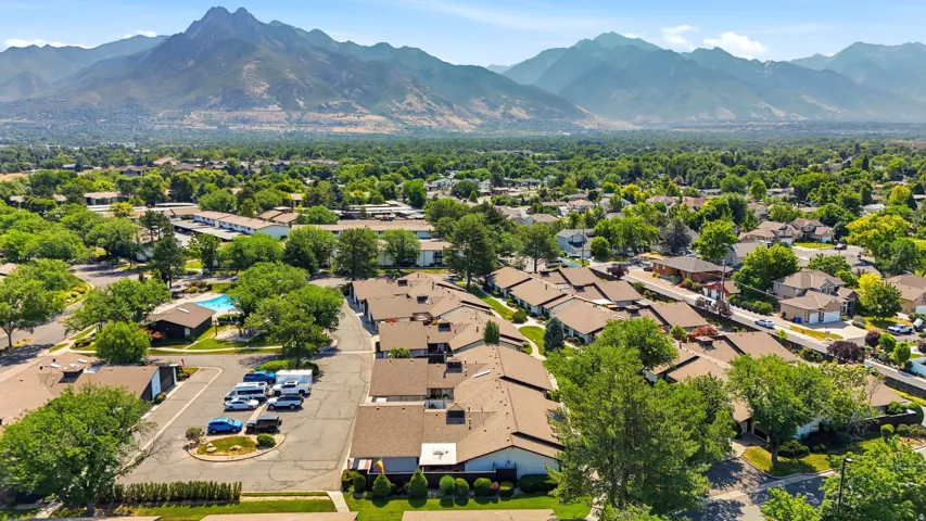 Expansive community with varied architectural styles, mature trees, and mountain scenery