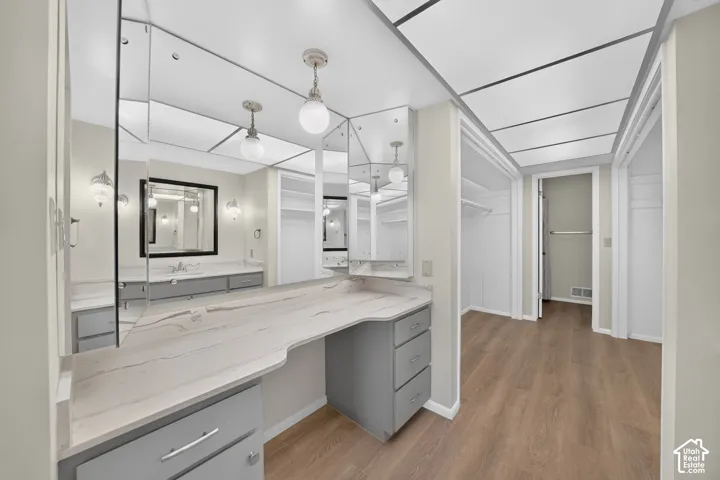 Vanity area featuring a built-in makeup desk with a light-colored countertop and grey cabinetry