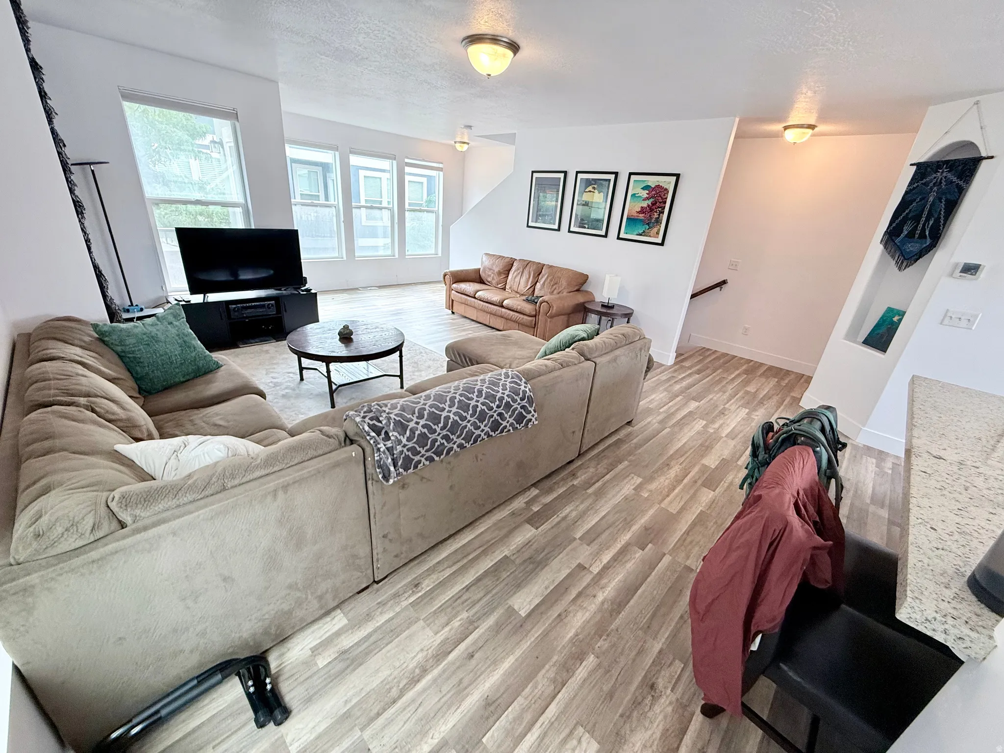 Spacious living area featuring wood-finish flooring and multiple recessed lighting fixtures