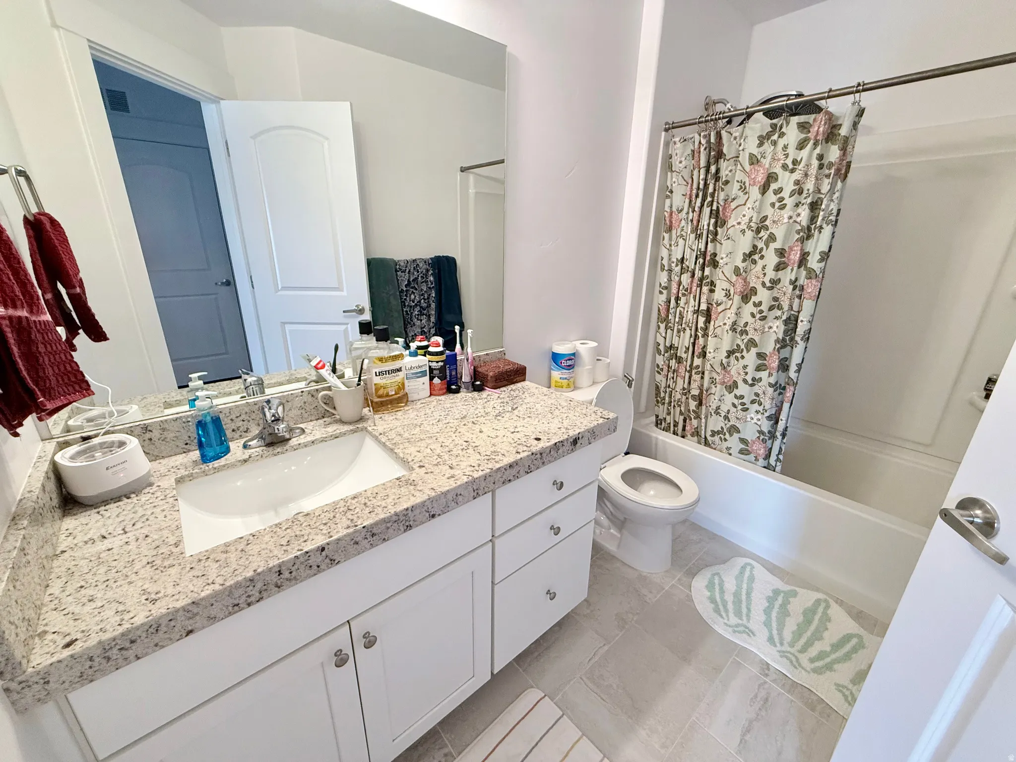 Bathroom featuring a white vanity with a granite countertop, undermount sink, and brushed-nickel faucet