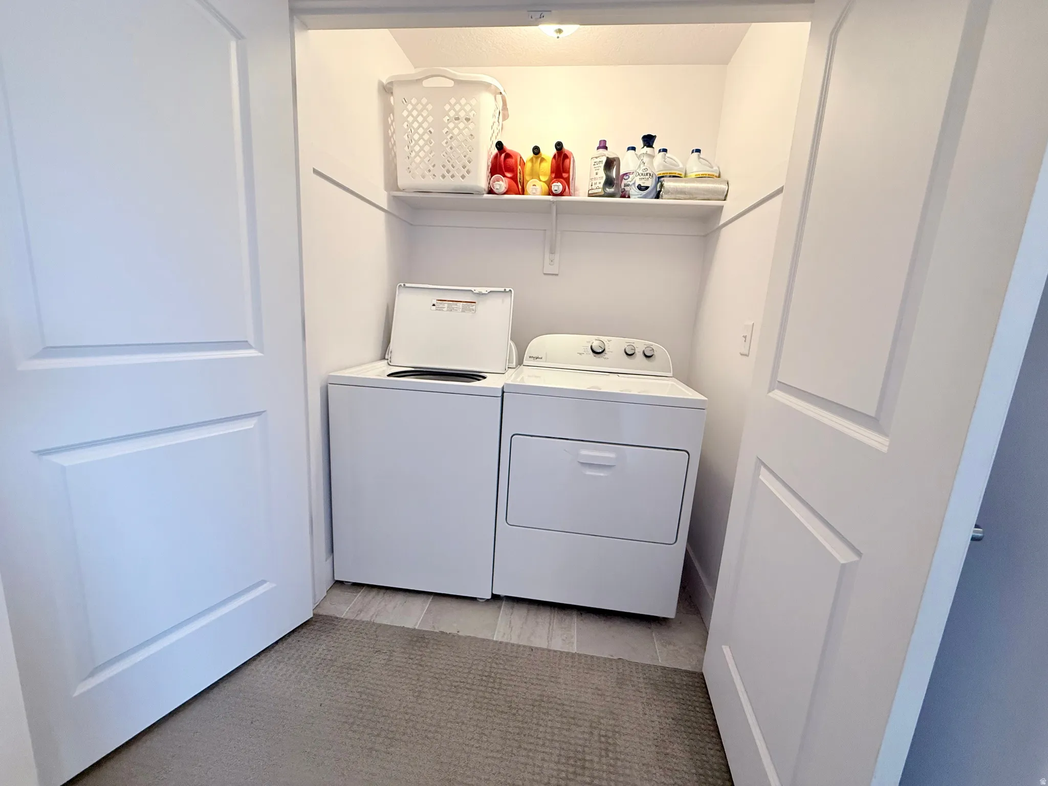Dedicated laundry area featuring a white top-load washer and front-load dryer