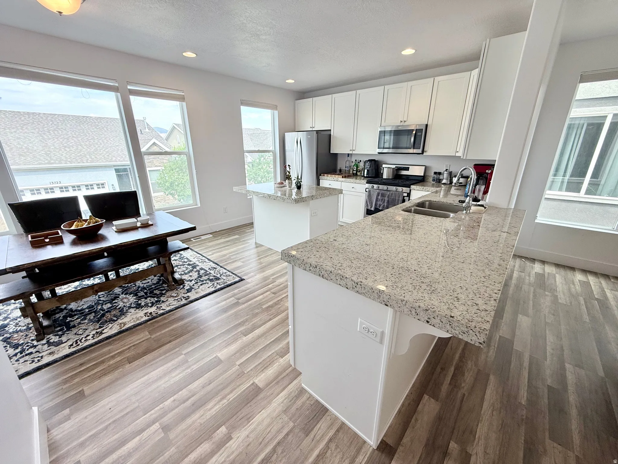 Open-concept kitchen and dining area featuring light-toned wood-finish flooring