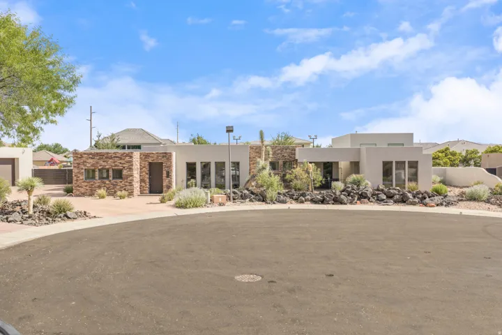 Contemporary exterior featuring stacked stone accents and a smooth stucco finish