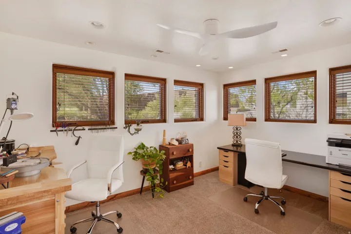 Bright room featuring multiple windows with wood trim, a contemporary ceiling fan, recessed lighting, and neutral carpet flooring