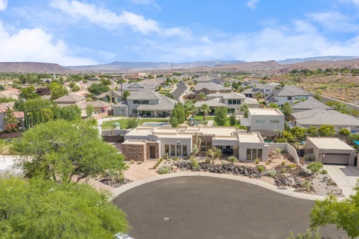 Modern stucco exterior with stone accents, a flat roofline, and attached two-car garage