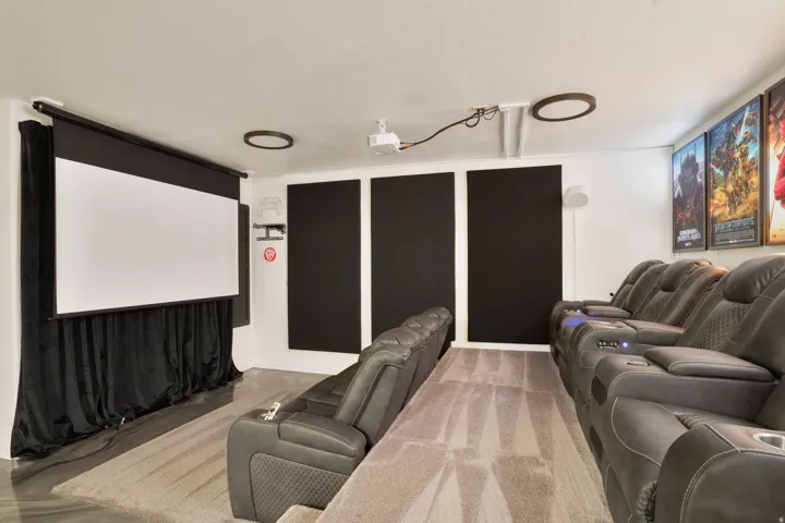 Dedicated home theater featuring a large projection screen, projector, and recessed ceiling lighting